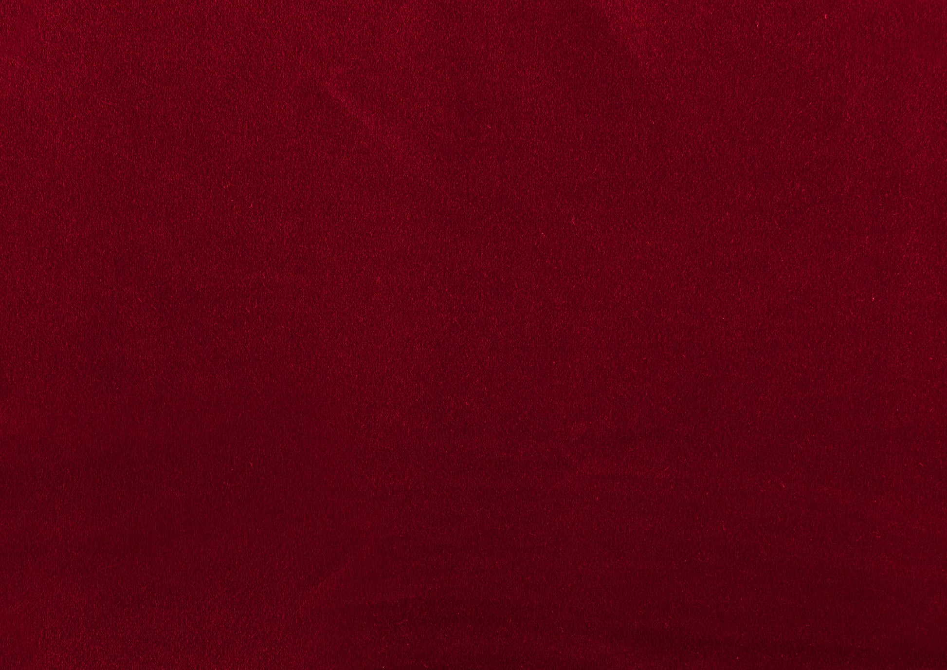 Rich deep red velvet fabric texture for luxurious upholstery applications