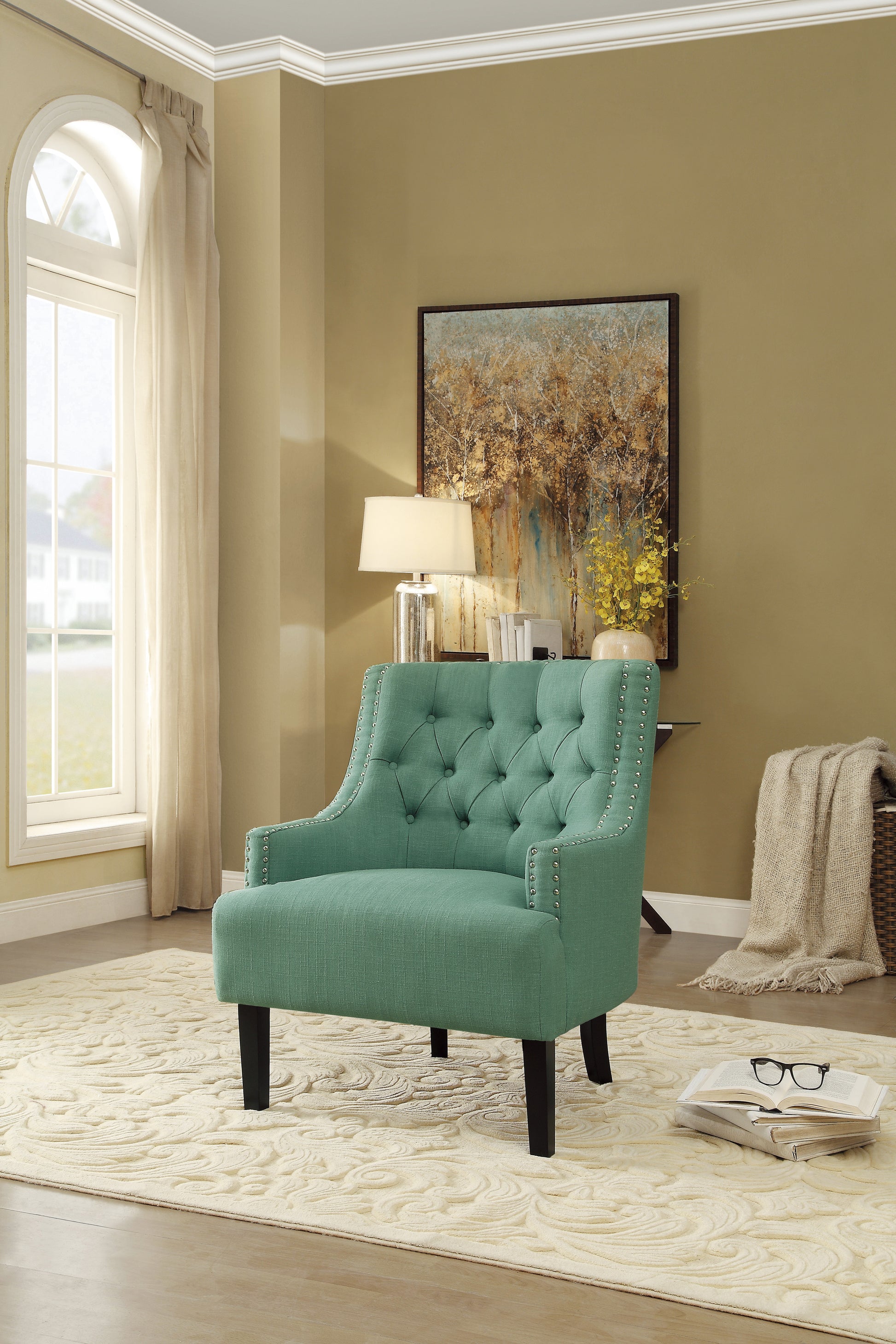 Teal tufted accent chair with silver nailhead trim and dark wood legs