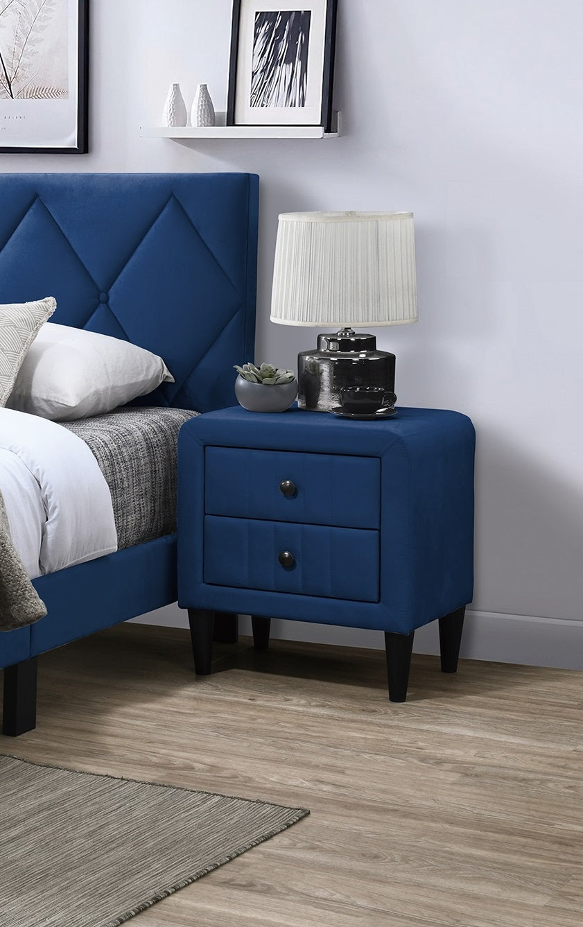 Navy blue upholstered nightstand with two drawers and round knobs beside a bed