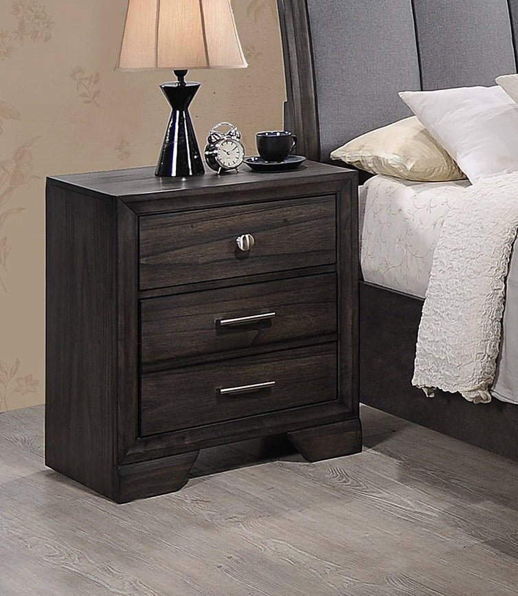 Dark wood threedrawer nightstand with silver hardware next to a bed