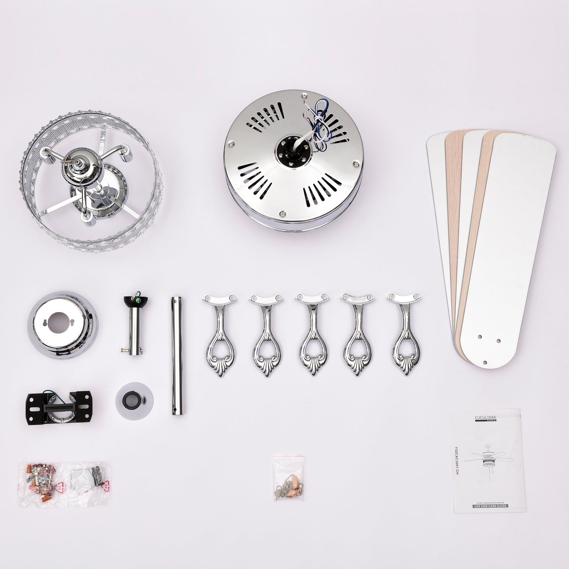 Silver ceiling fan parts laid out for assembly including motor housing and blades