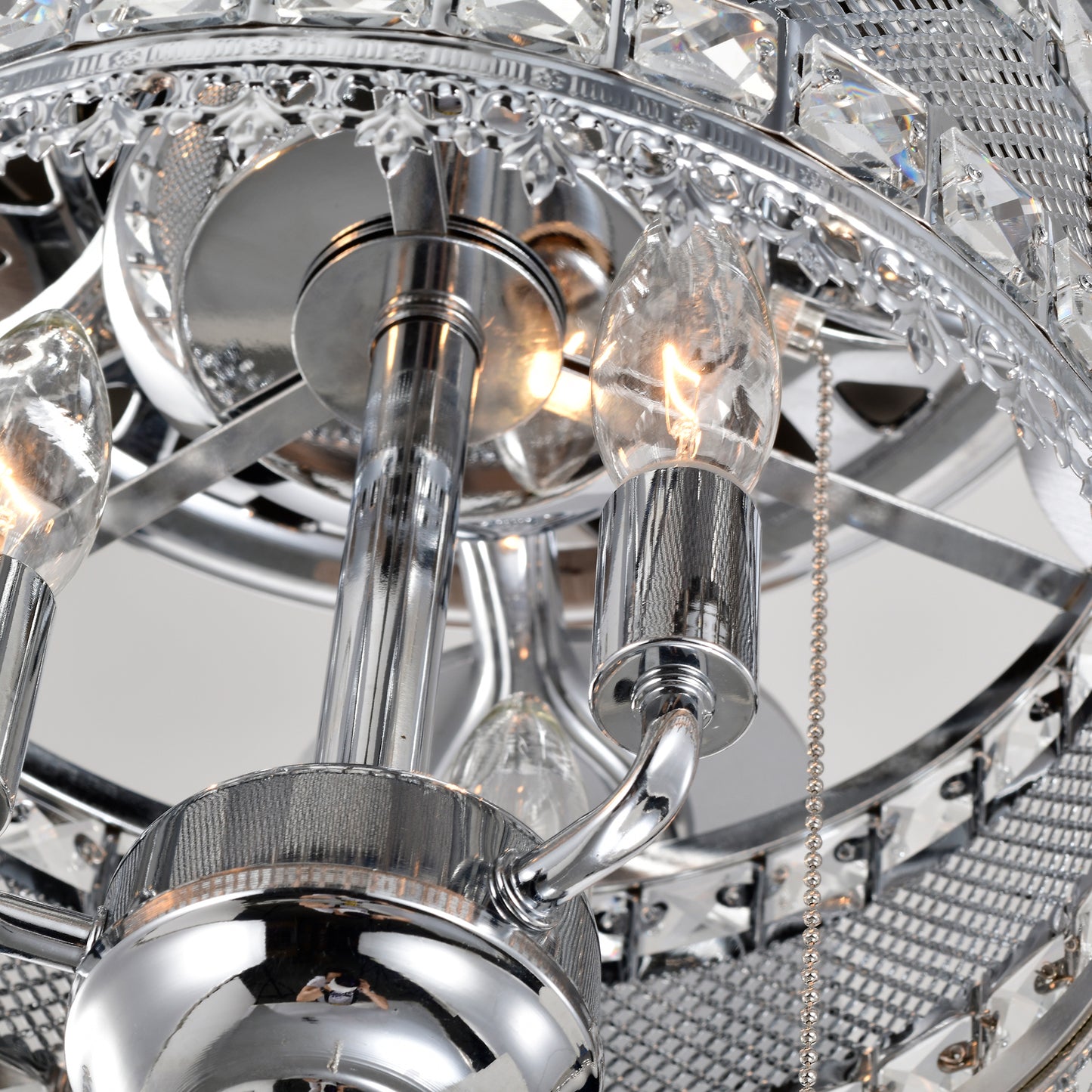 Close up of a chrome chandelier with crystal accents and exposed bulbs showcasing intricate detailing