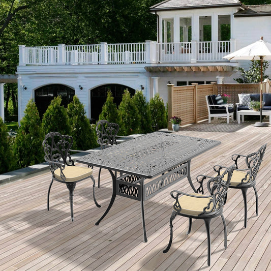 Black cast aluminum patio dining set with ornate chairs and rectangular table