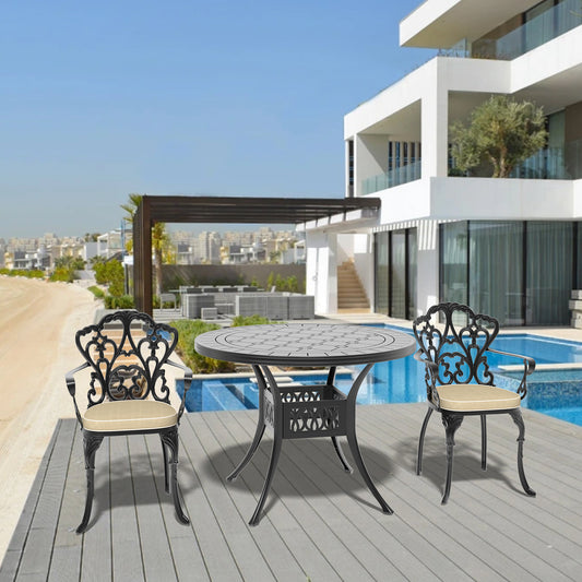 Black ornate cast aluminum patio dining set with round table and cushioned chairs