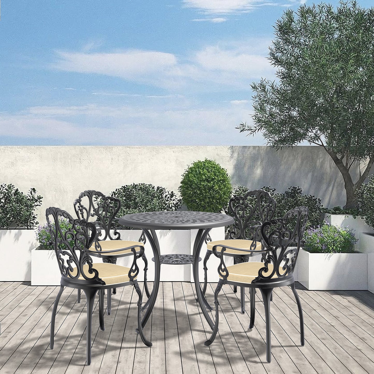 Black cast iron bistro set with ornate detailing and tan cushions