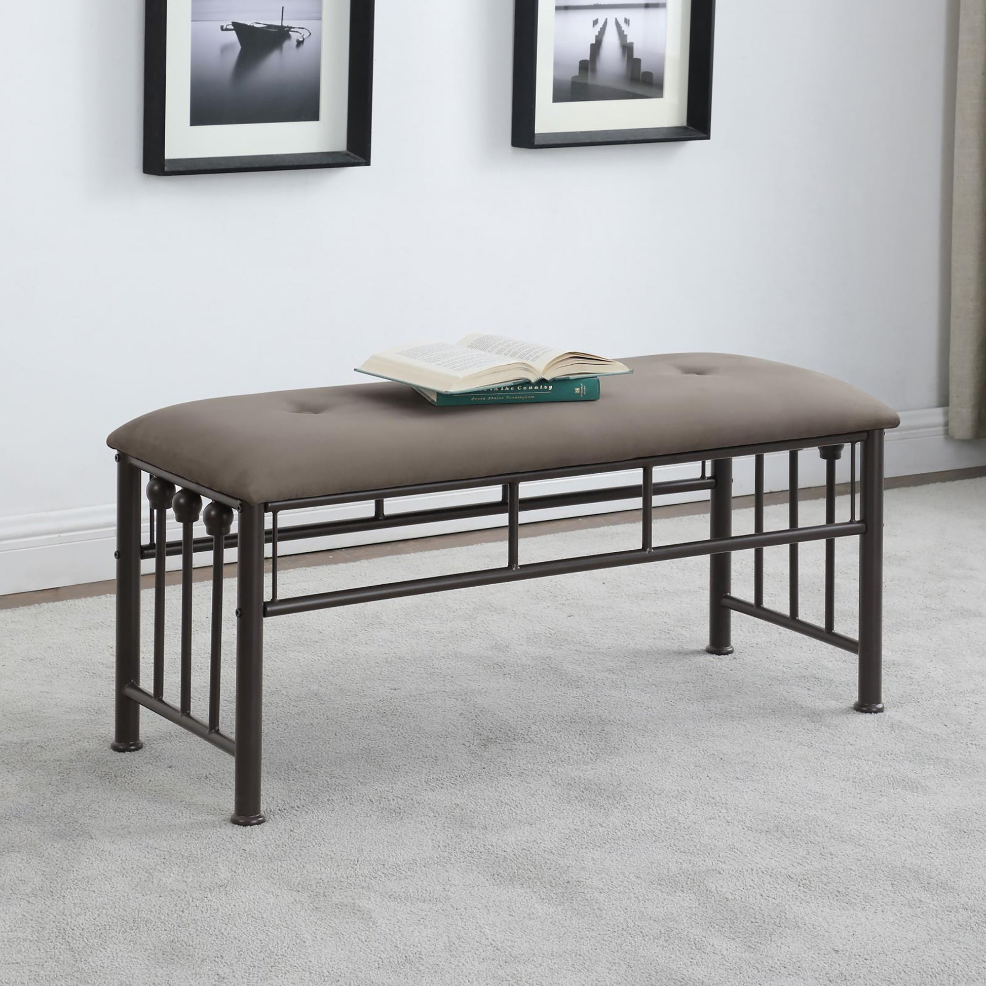 Tufted grey upholstered bench with dark metal frame and decorative finials perfect for entryway
