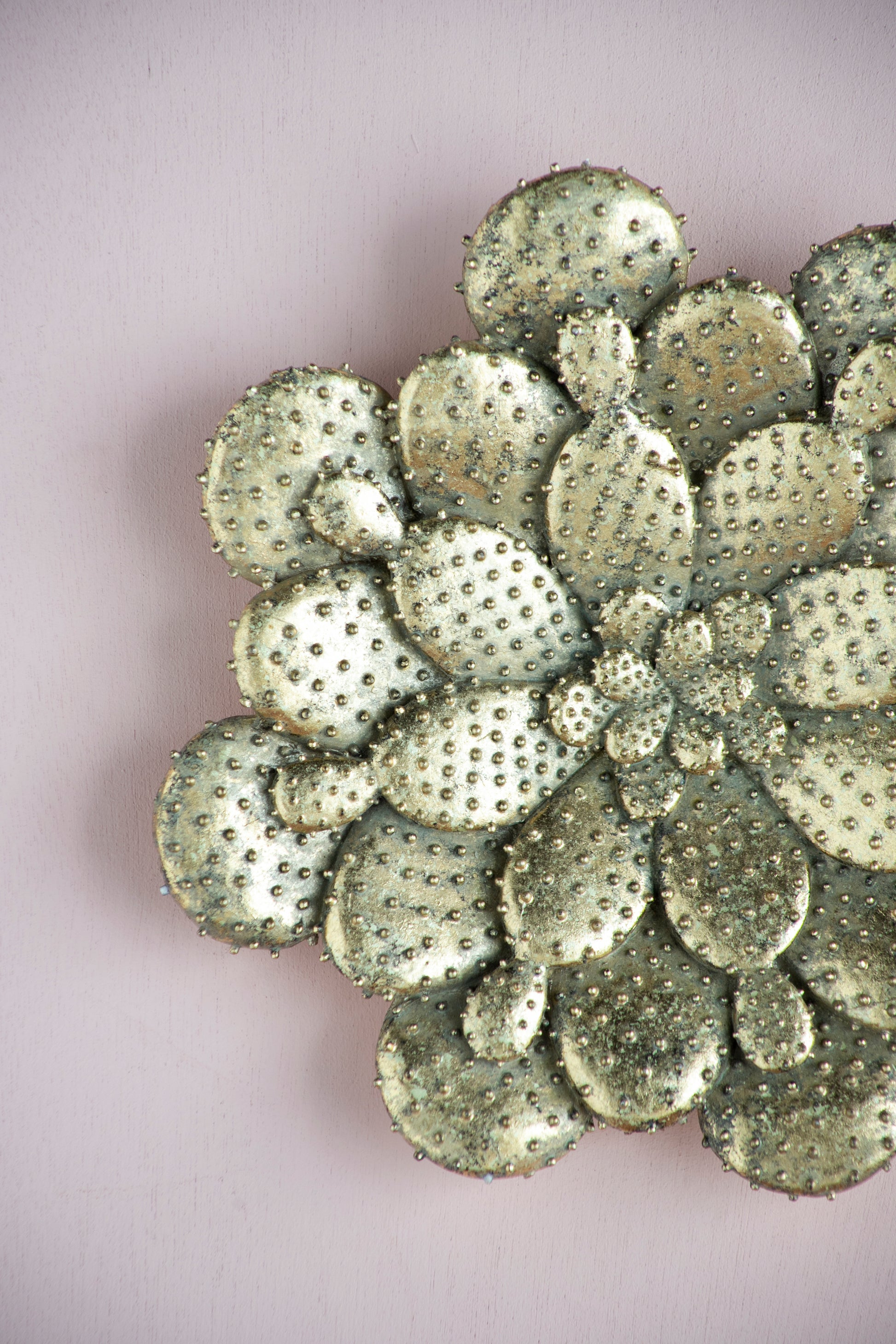 Textured gold metal wall art resembling prickly pear cactus pads with raised studs
