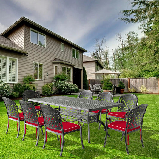 Ornate cast aluminum patio dining set with intricate lattice backs and red cushions