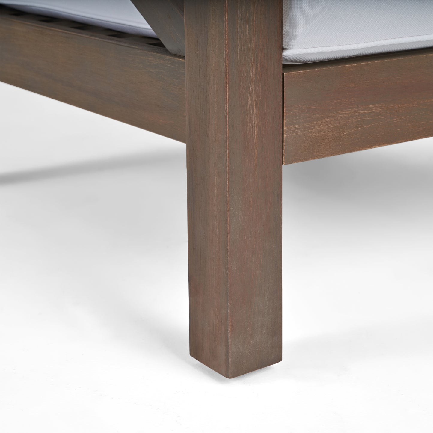 Closeup of a dark brown wooden chair leg showcasing its rustic texture