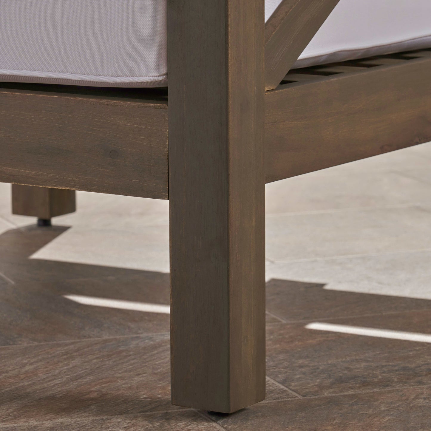 Dark brown wooden outdoor chair leg with white cushion detail