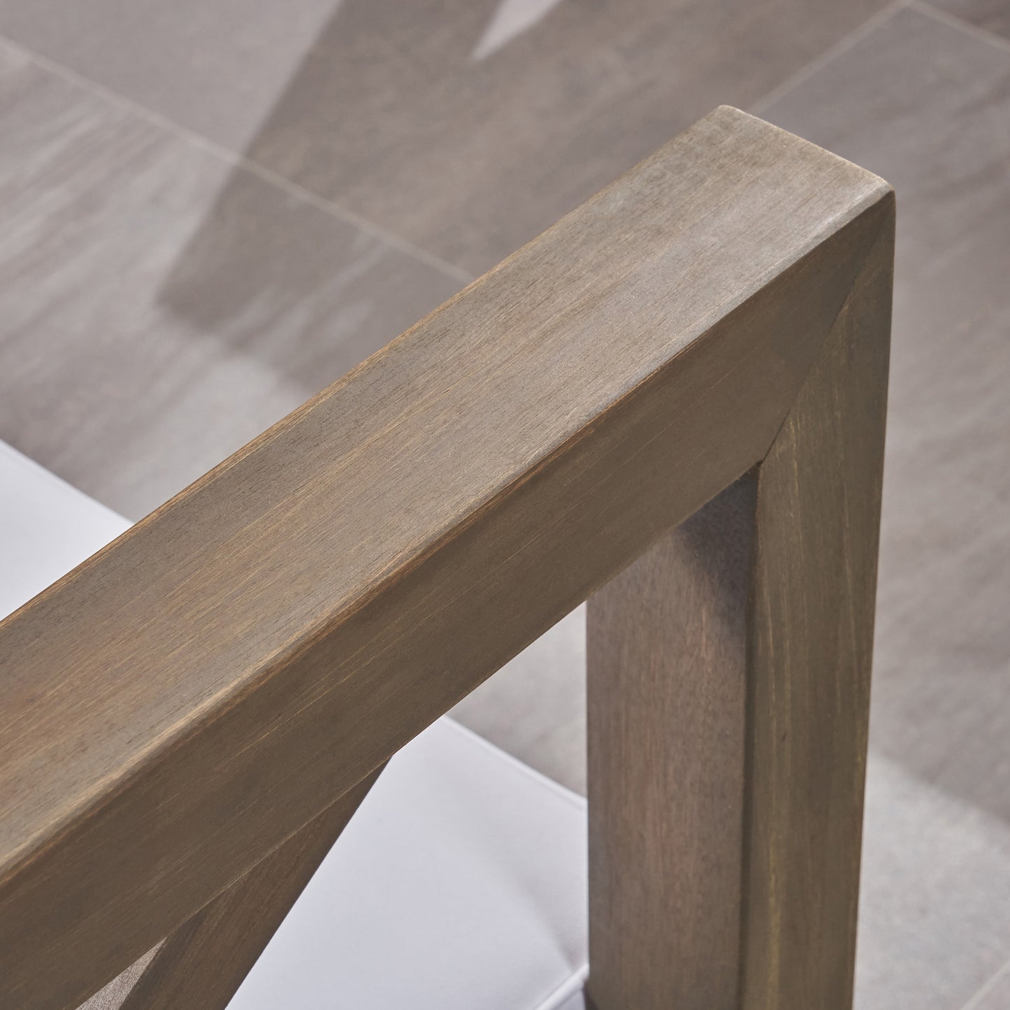 Closeup of weathered oak wood armrest on outdoor patio furniture