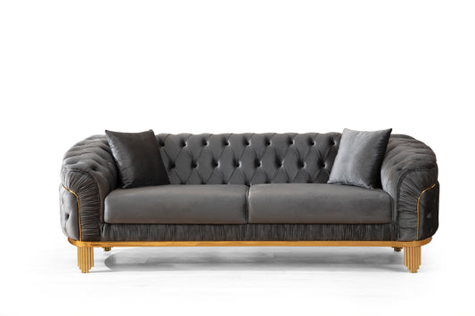 Elegant dark grey velvet chesterfield sofa with gold accents and decorative tufting