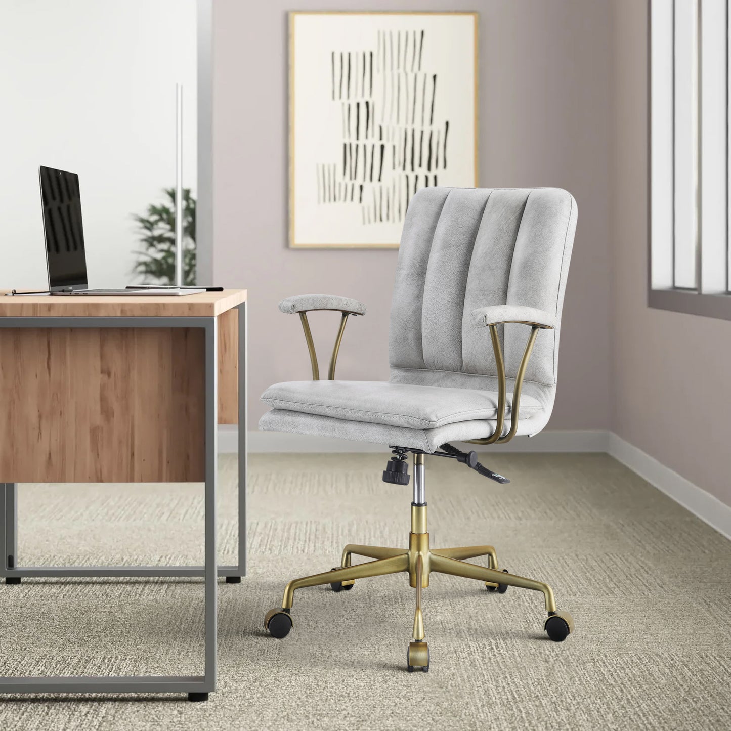 Light gray upholstered office chair with channel tufting and brass accents perfect for a stylish desk setup