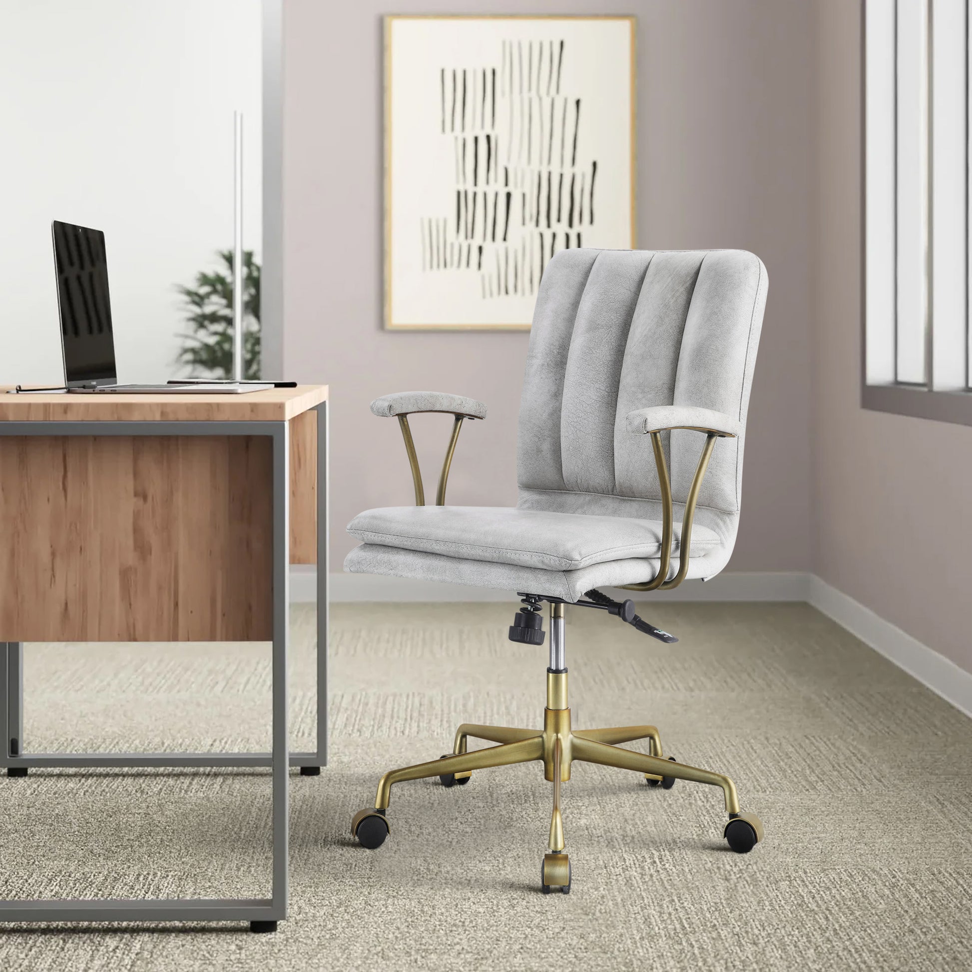 Light gray upholstered office chair with channel tufting and brass accents perfect for a stylish desk setup