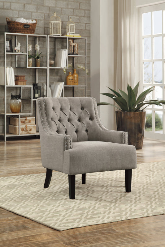 Gray tufted accent chair with silver nailhead trim and dark wooden legs