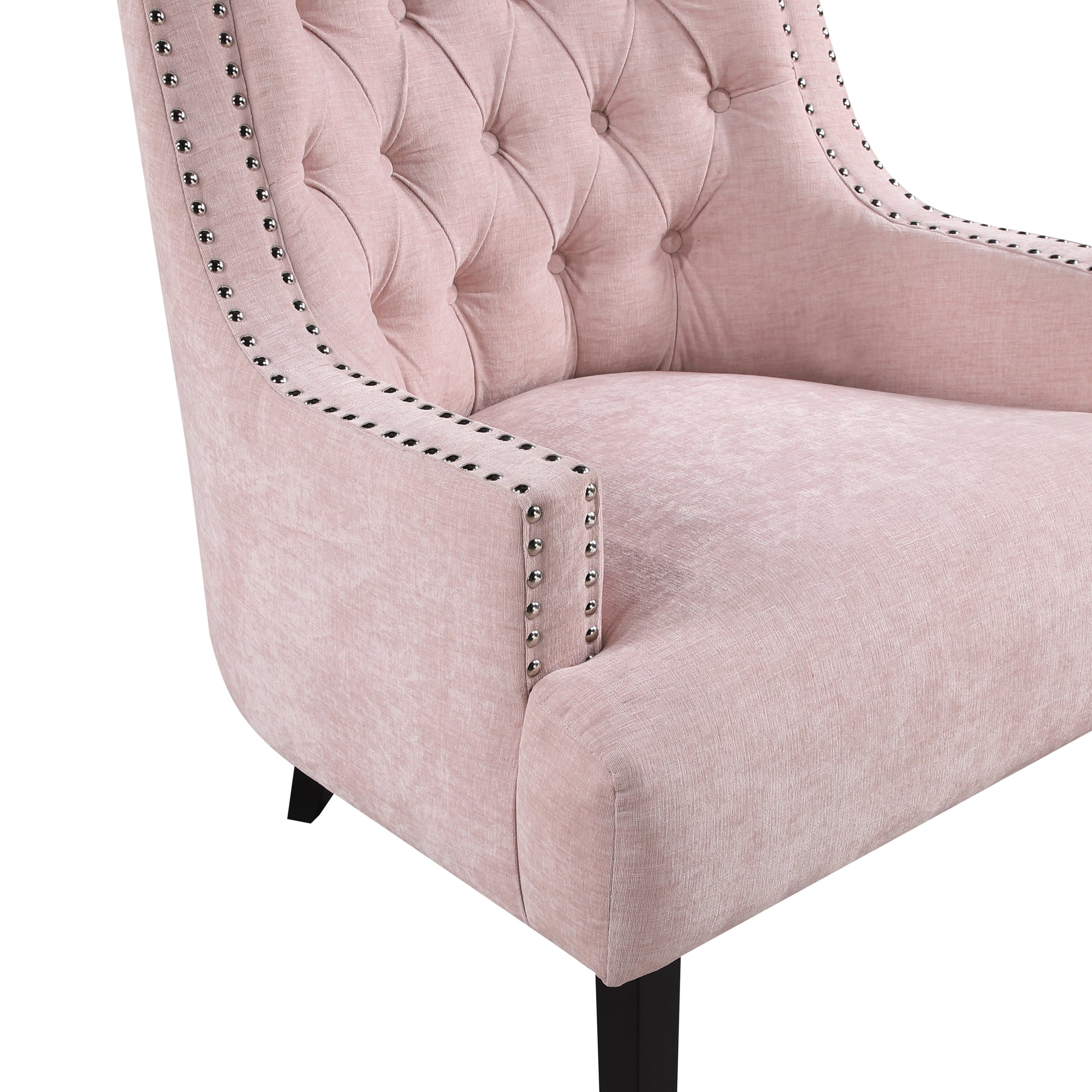 Closeup of a pink velvet accent chair with tufted back and silver nailhead trim