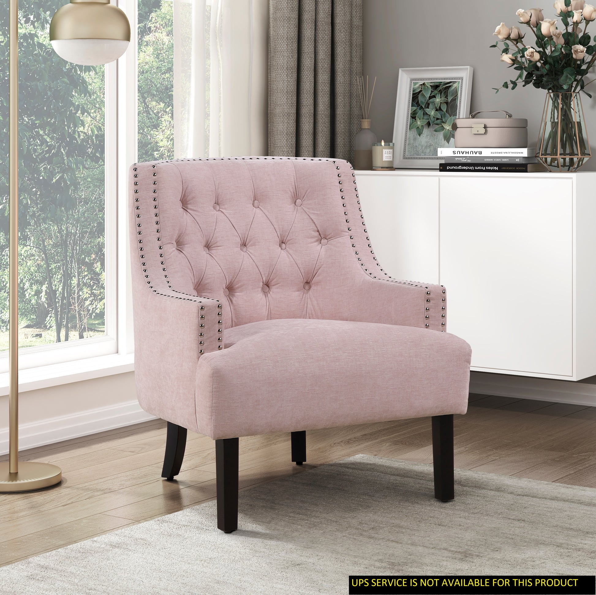Tufted pink armchair with silver nailhead trim and dark wooden legs