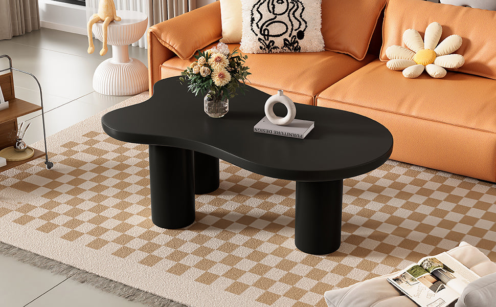 Organic shaped black coffee table with rounded cylindrical legs perfect for modern living rooms
