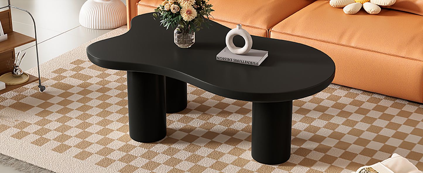 Black irregularshaped coffee table with round cylindrical legs