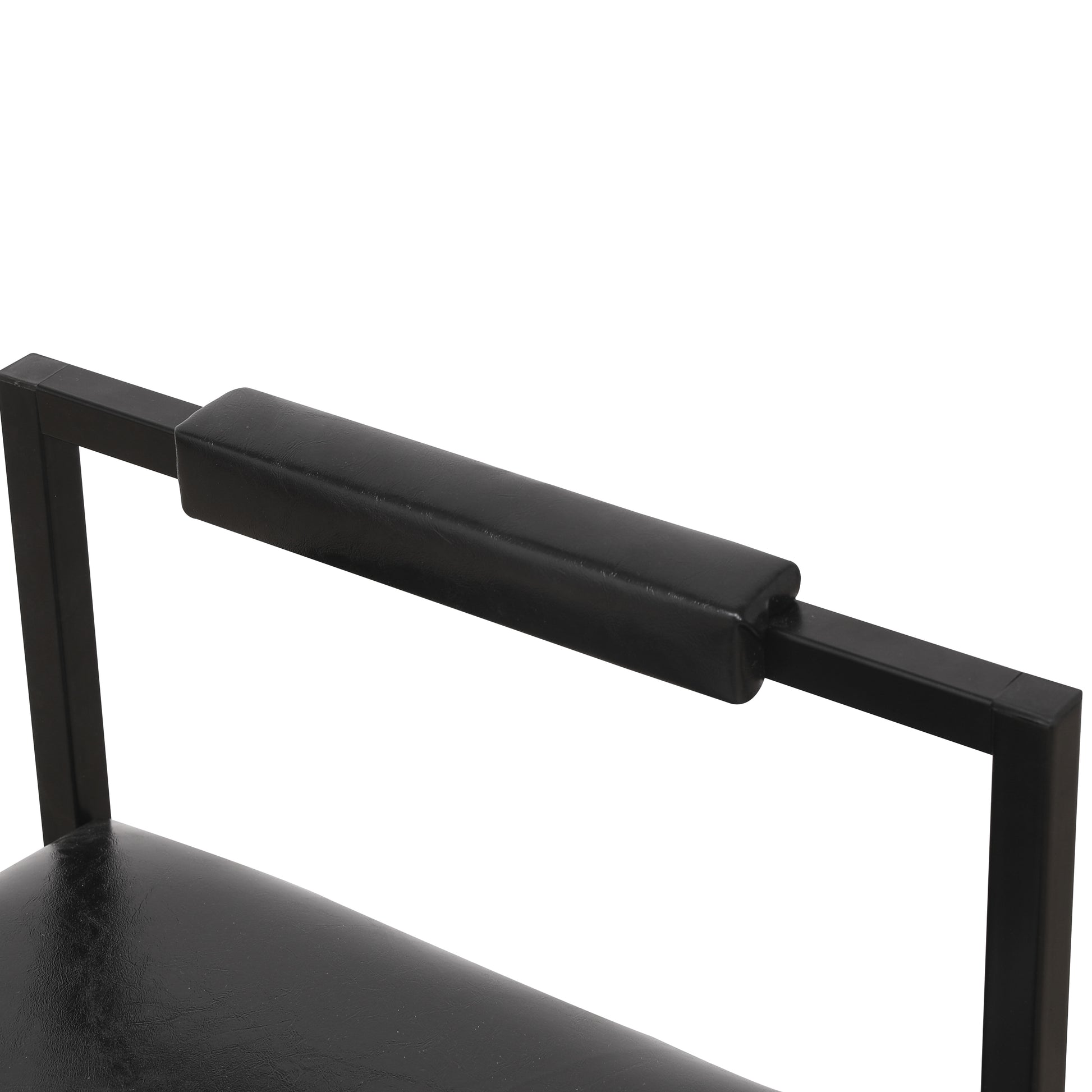 Closeup of a black faux leather armchair armrest with metal frame