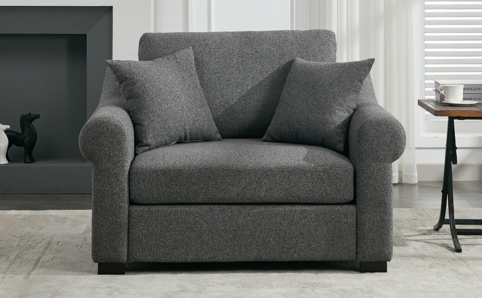 Dark grey fabric loveseat with rolled arms and two accent pillows perfect for small spaces
