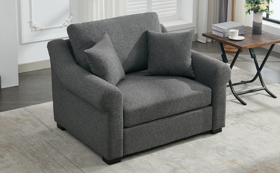 Dark grey upholstered accent chair with plush throw pillows perfect for small living spaces