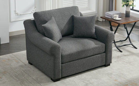 Dark grey upholstered accent chair with plush throw pillows perfect for small living spaces