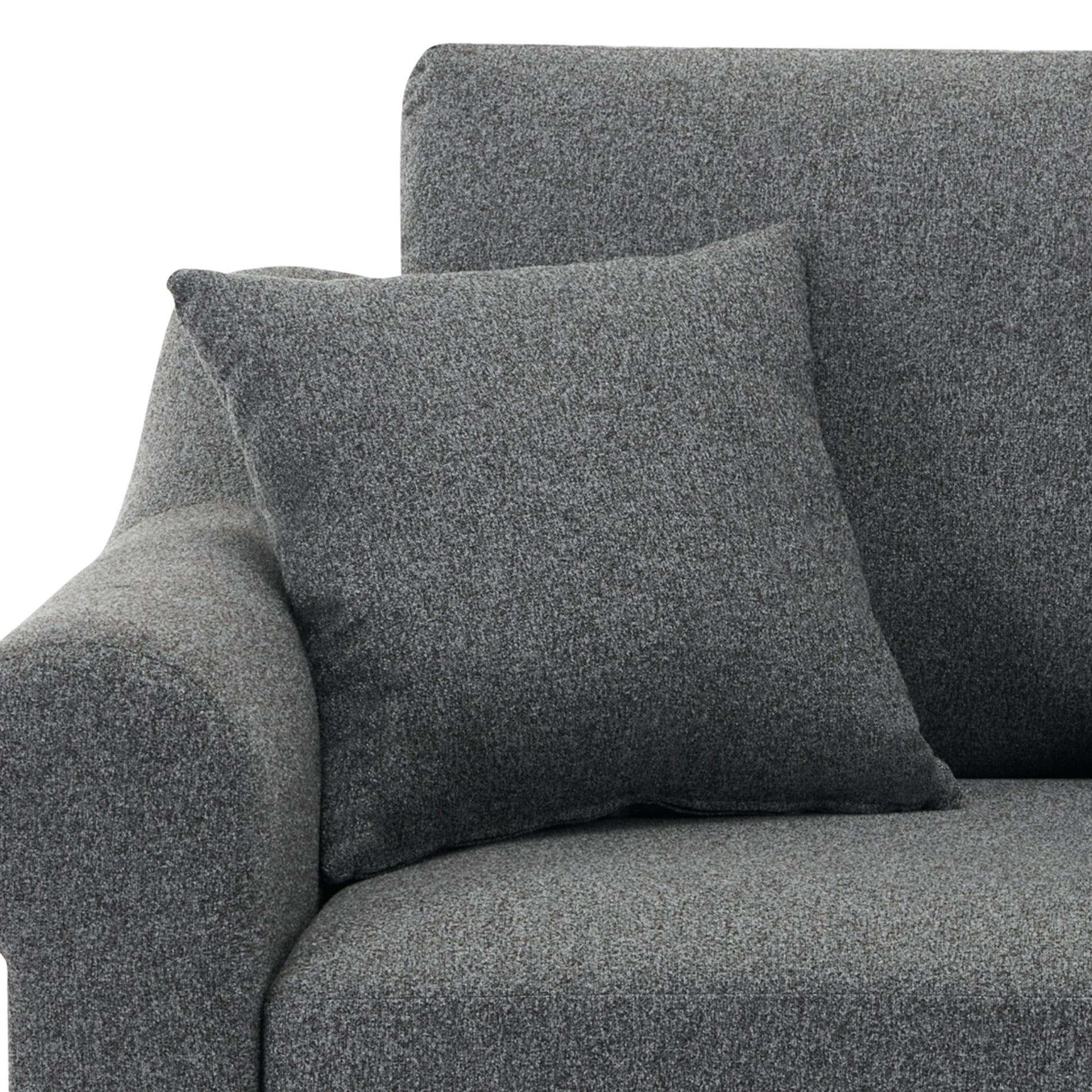 Closeup of a textured charcoal grey throw pillow on a matching sofa