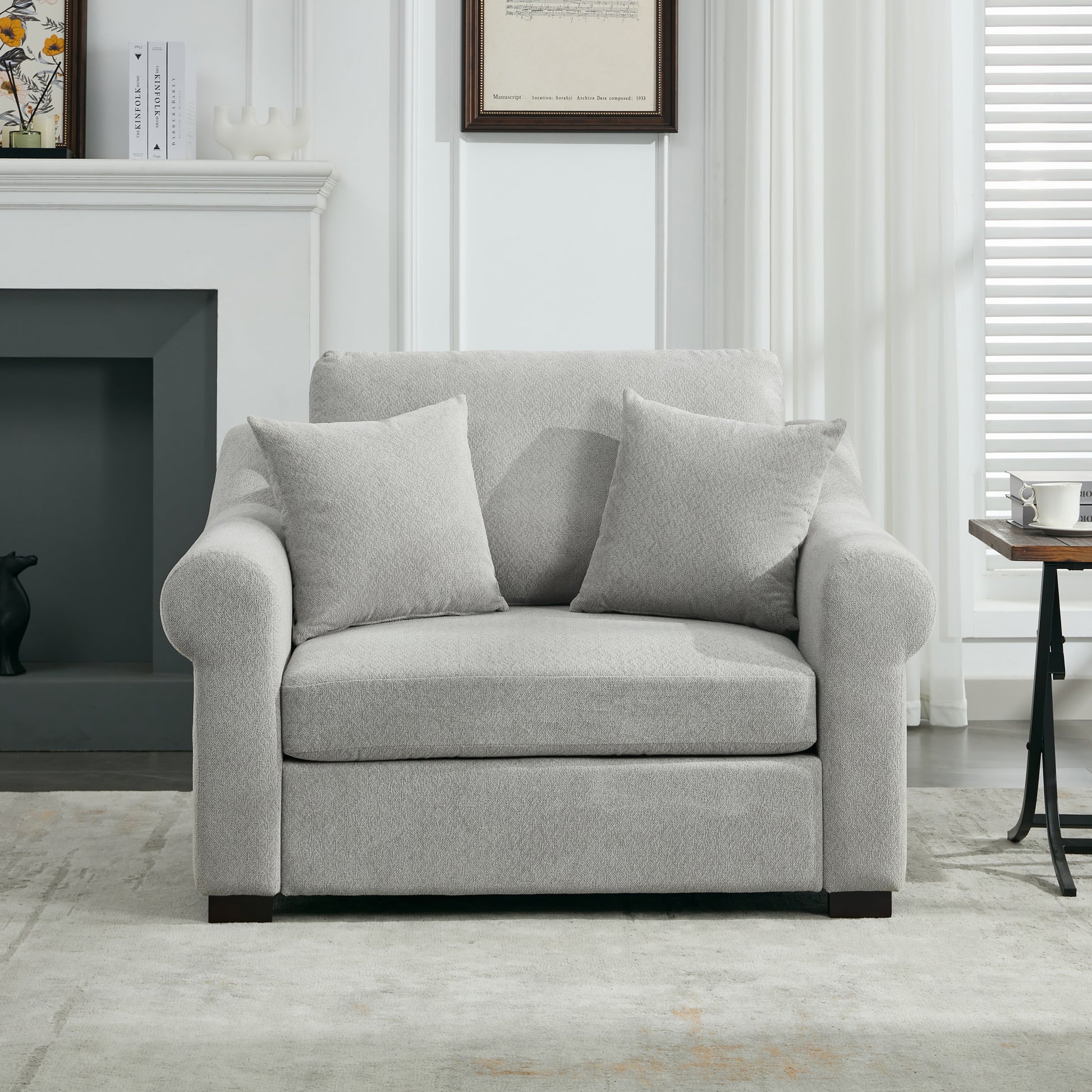 Plush grey fabric armchair with two throw pillows perfect for a modern living room
