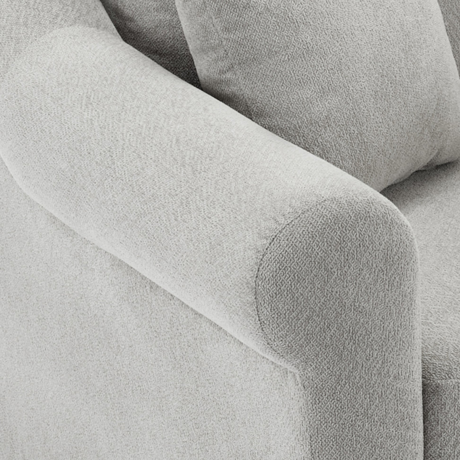 Closeup of a textured gray linen sofa armrest offering plush comfort and style