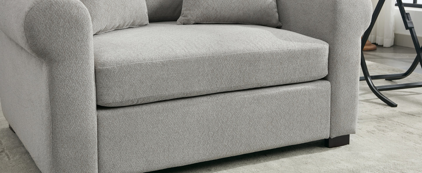 Closeup of a plush grey armchair with textured fabric and rolled arms