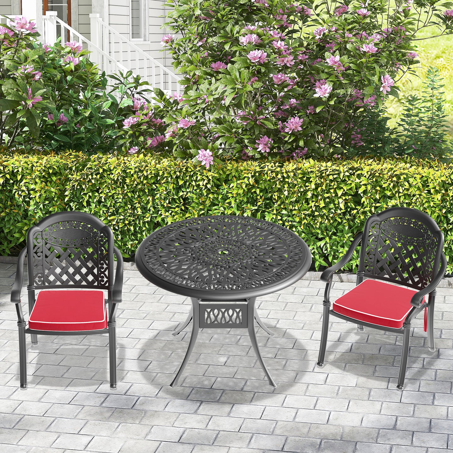 Black ornate cast aluminum patio set with two chairs and a round table featuring red cushions