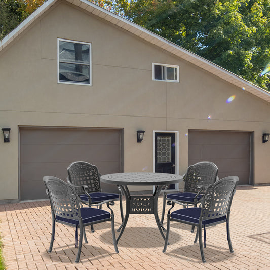 Ornate cast iron patio dining set with four chairs and a round table perfect for outdoor entertaining