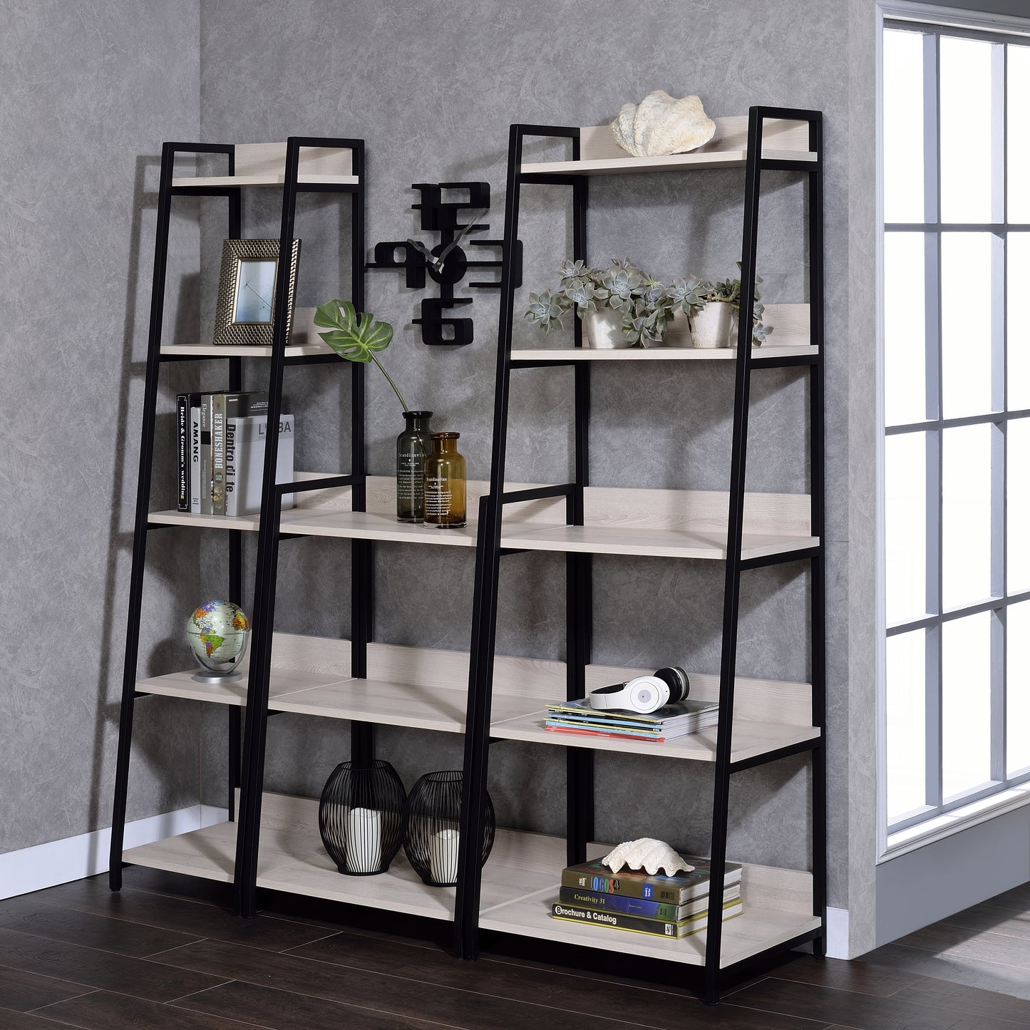 Black metal and light wood ladder bookshelf with framed art and plants