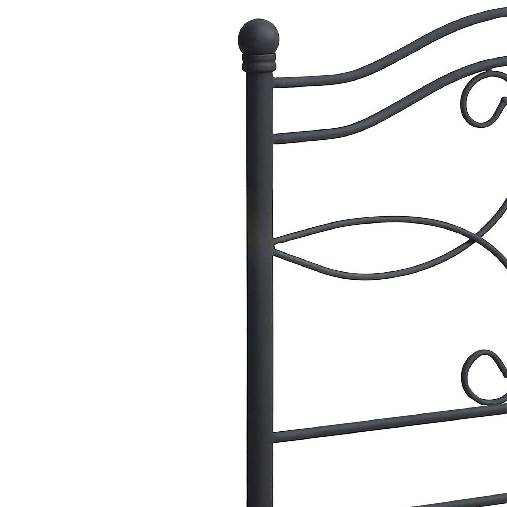 Dark grey metal bed frame detail with finial