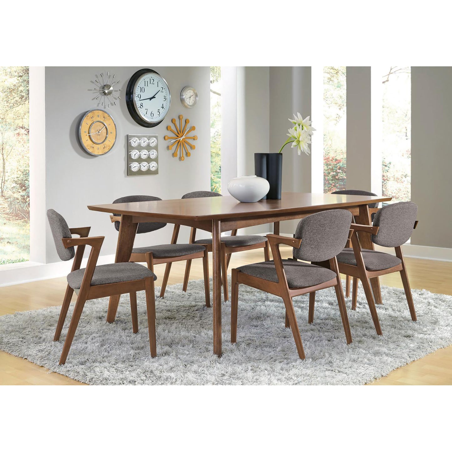 Midcentury modern dining table with dark wood finish and upholstered grey chairs