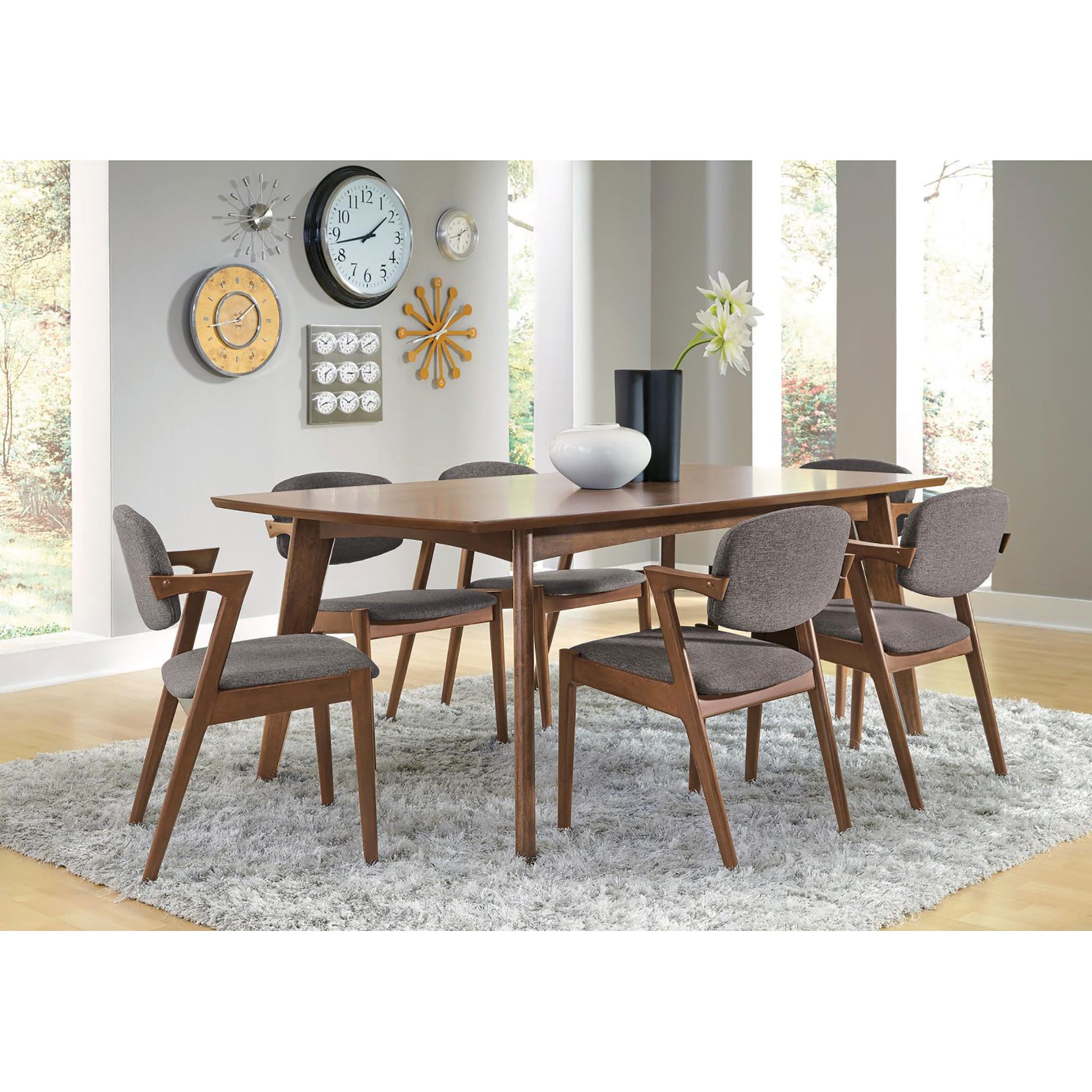 Midcentury modern dining table with dark wood finish and upholstered grey chairs