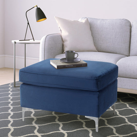 Deep blue velvet ottoman with silver tapered legs a plush and inviting accent piece