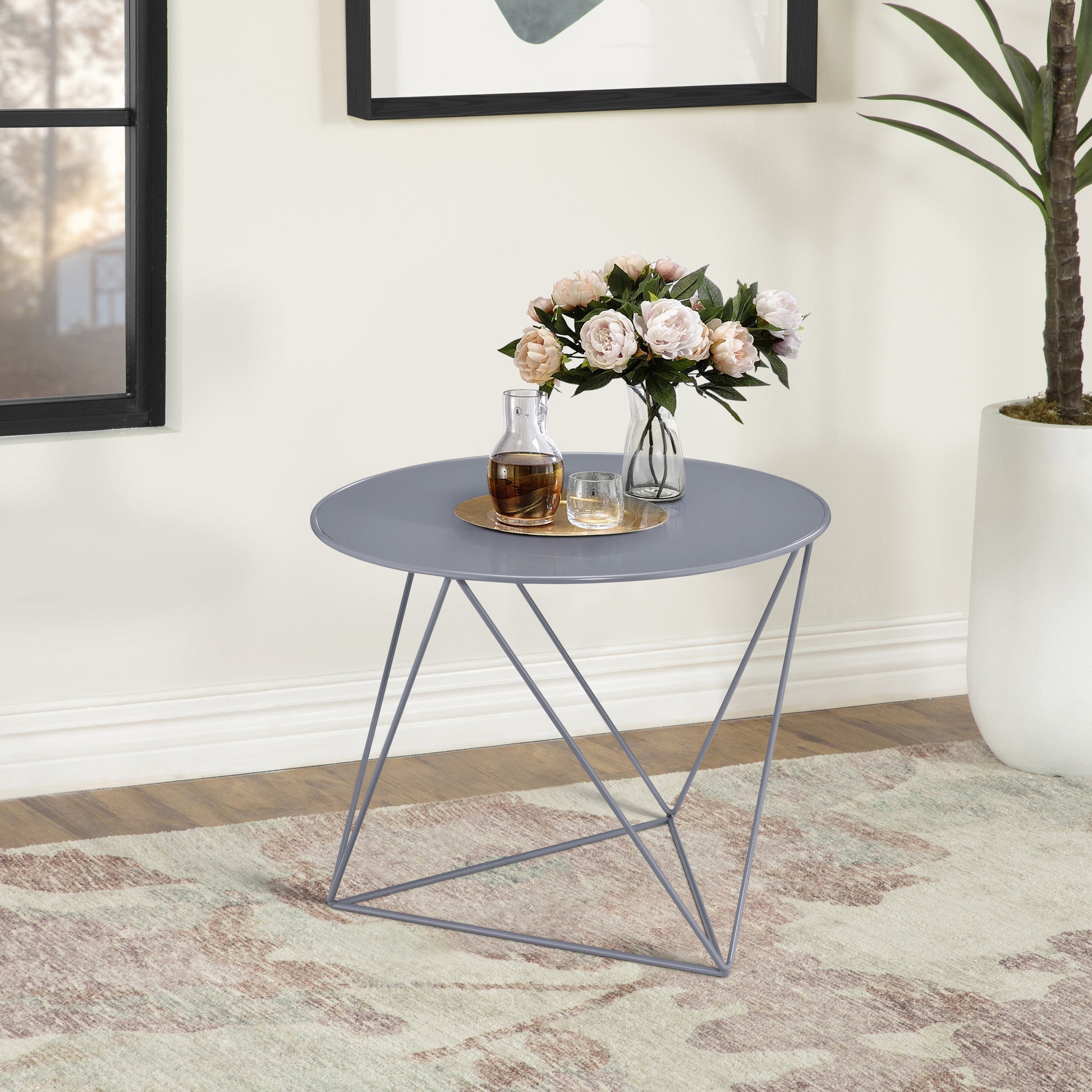 Sleek grey metal accent table with a circular top ideal for a modern living room