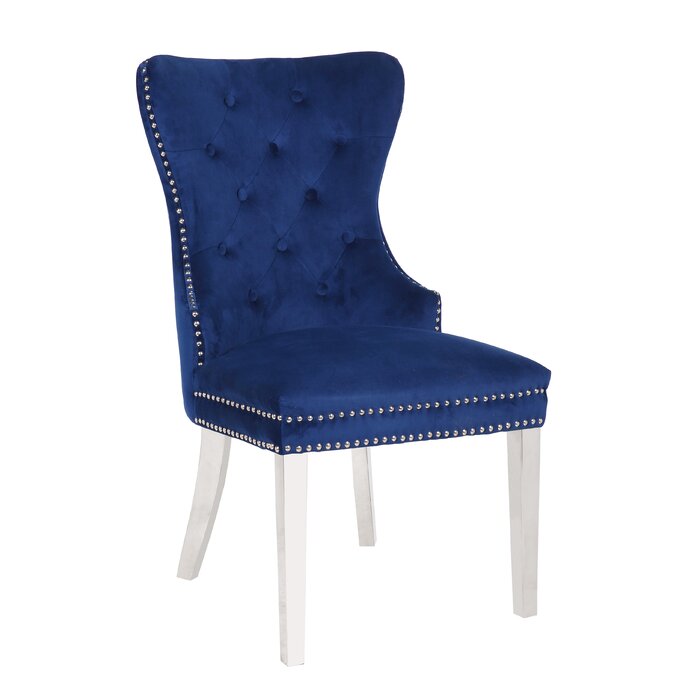 Deep navy velvet wingback dining chair with button tufting and silver nailhead trim