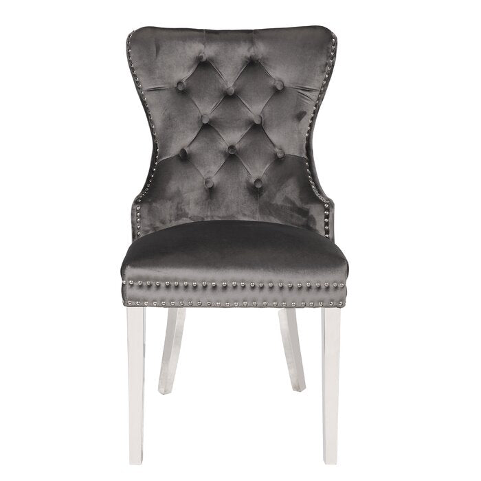 Dark grey velvet dining chair with tufted back and silver nailhead trim