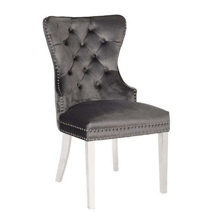 Elegant grey velvet wingback chair with button tufting and silver nailhead trim