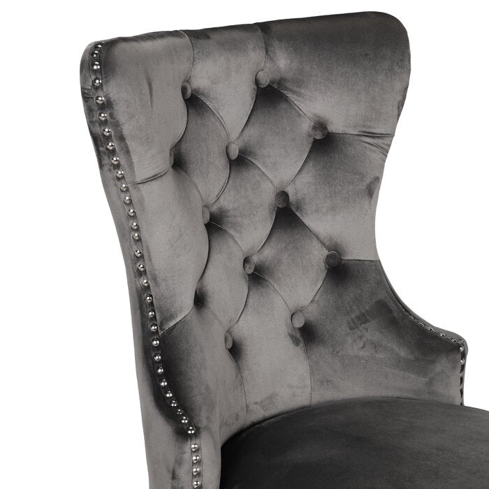 Grey velvet wingback chair with diamond tufting and silver nailhead trim