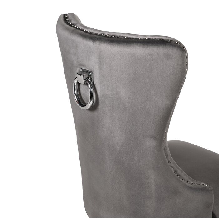 Grey velvet dining chair with chrome ring pull and stud detail on back
