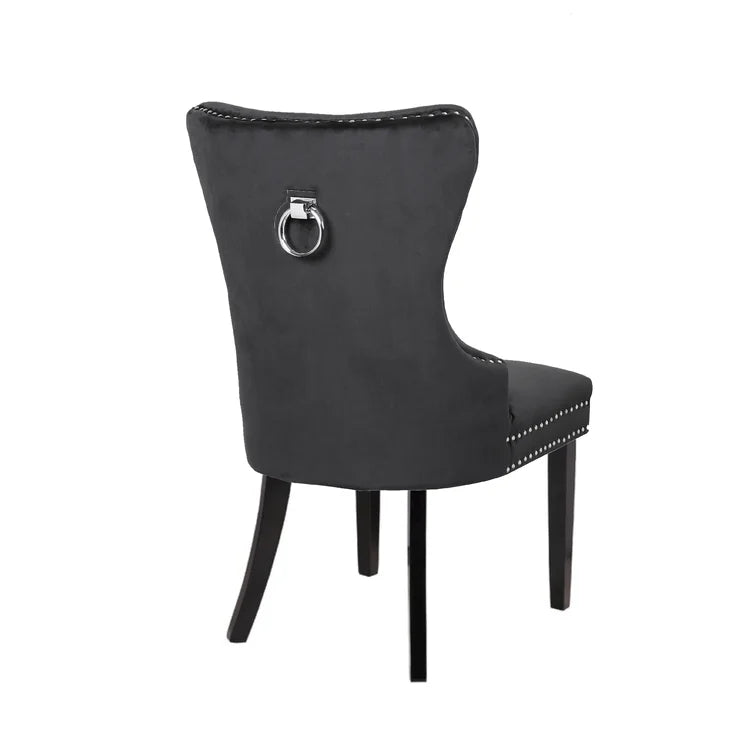 Tufted black velvet dining chair with silver ring pull detail and studded trim