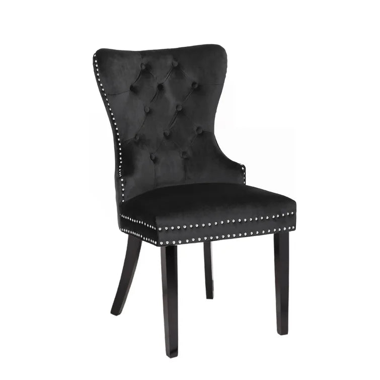 Black velvet dining chair with diamond tufting and silver nailhead trim
