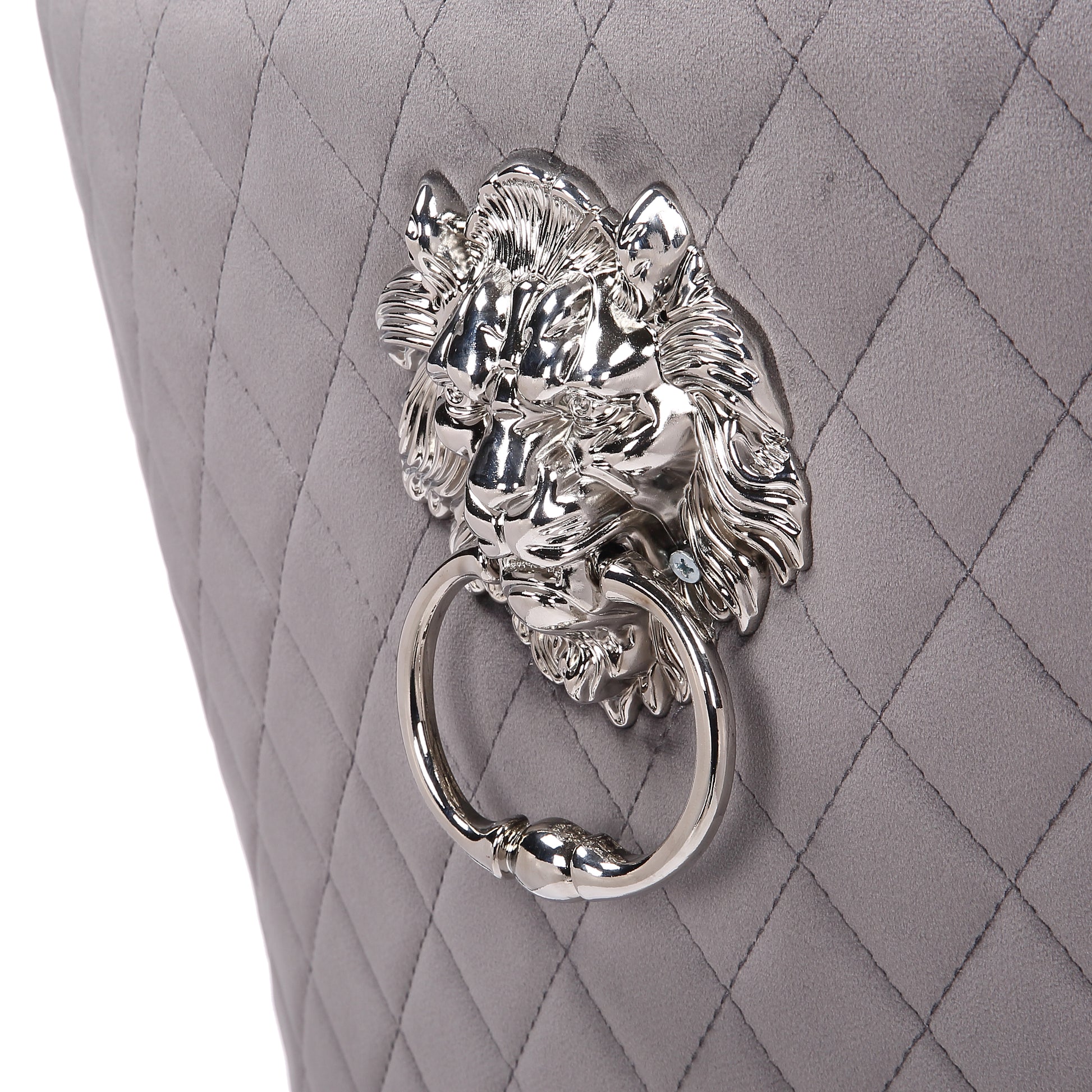 Closeup of a quilted grey velvet chair back with a silver lion head knocker detail
