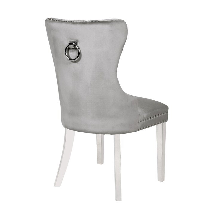 Grey velvet dining chair with silver ring pull on back and stud detailing