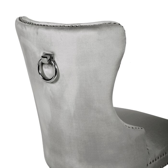 Grey velvet dining chair with silver ring pull detail and studded trim