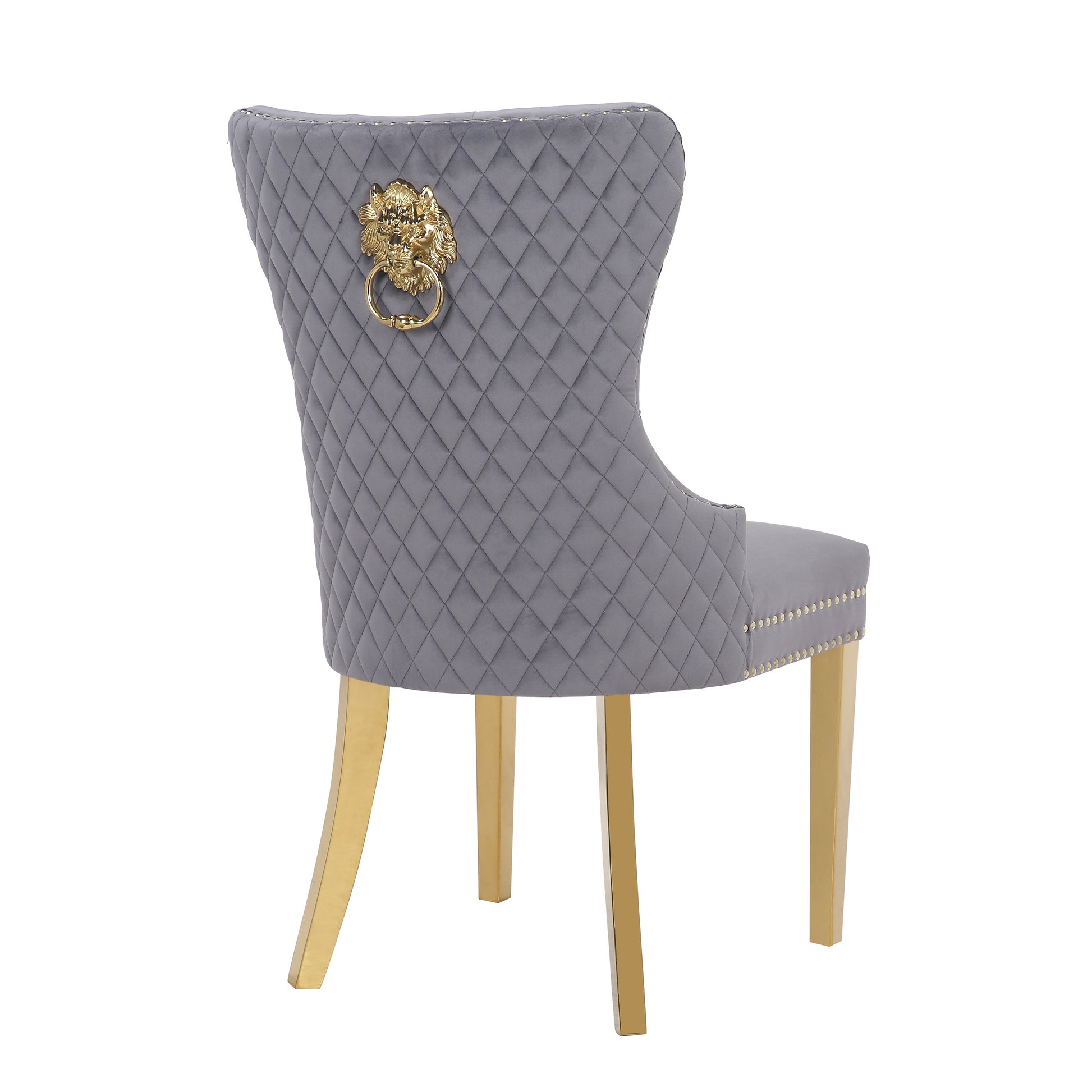 Grey velvet dining chair with diamond tufting and gold lion head accent